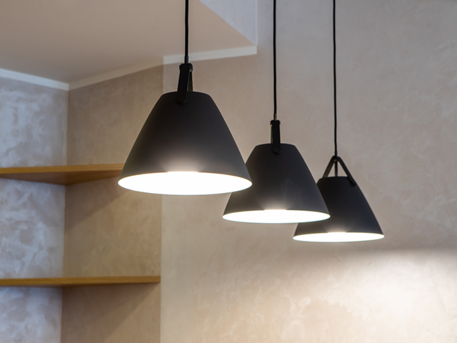 Close-up of black lamps on ceiling. Modern interior. Wooden shelves.